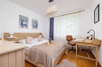 a bedroom with a bed and a desk and a table at Cozy Apartment with Parking in Kraków by Noclegi Renters in Kraków