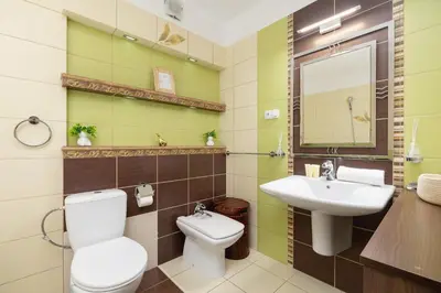 a bathroom with a toilet and a sink and a mirror at Cozy Apartment with Parking in Kraków by Noclegi Renters in Kraków