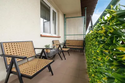 a row of chairs and tables on a balcony at Cozy Apartment with Parking in Kraków by Noclegi Renters in Kraków