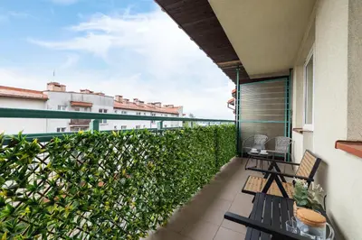 a balcony with two chairs and a fence at Cozy Apartment with Parking in Kraków by Noclegi Renters in Kraków