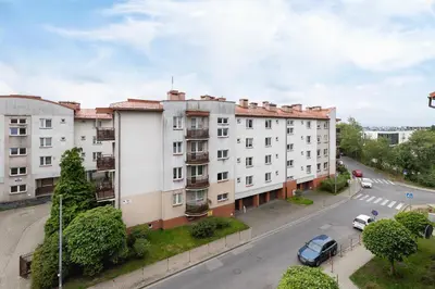 an apartment building with cars parked on the street at Cozy Apartment with Parking in Kraków by Noclegi Renters in Kraków