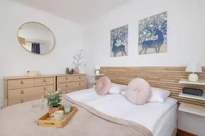 a bedroom with two beds with pink pillows and a mirror at Cozy Apartment with Parking in Kraków by Noclegi Renters in Kraków