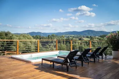 a deck with a pool with chairs and a table at Dom 