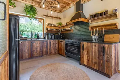 a kitchen with wooden cabinets and a black refrigerator at Dom 