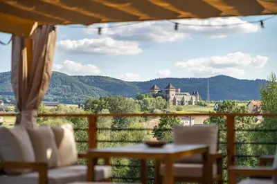 a table and chairs on a balcony with a castle at Dom 