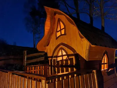 a gingerbread house on a fence at night at Domki Pod Biegunem, Wioska Smerfów oraz Wzgórze Gargamela in Żywiec