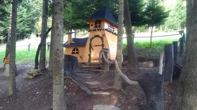 a small house in the middle of some trees at Domki Pod Biegunem, Wioska Smerfów oraz Wzgórze Gargamela in Żywiec