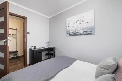 a bedroom with a bed and a desk at Przytulny Apartament z 3 sypialniami z Biurkiem do Pracy Zdalnej by Noclegi Renters in Kraków