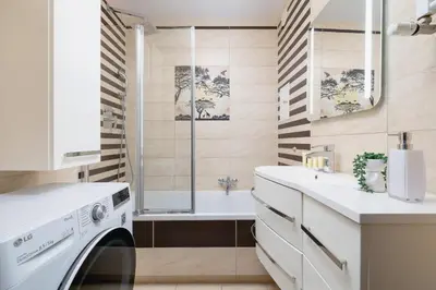 a bathroom with a washing machine and a tub at Przytulny Apartament z 3 sypialniami z Biurkiem do Pracy Zdalnej by Noclegi Renters in Kraków