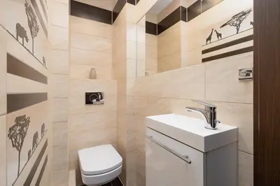 a small bathroom with a toilet and a sink at Przytulny Apartament z 3 sypialniami z Biurkiem do Pracy Zdalnej by Noclegi Renters in Kraków