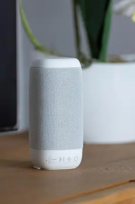 a small white speaker sitting on a table at Przytulny Apartament z 3 sypialniami z Biurkiem do Pracy Zdalnej by Noclegi Renters in Kraków