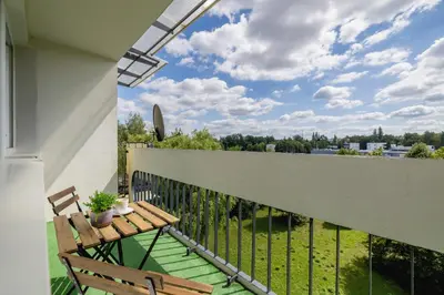 a balcony with a wooden bench and a view at Przytulny Apartament z 3 sypialniami z Biurkiem do Pracy Zdalnej by Noclegi Renters in Kraków