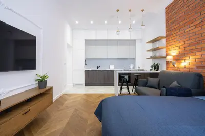 a bedroom with a bed and a living room at Studio apartment - Starowiślna 41 street in Kraków