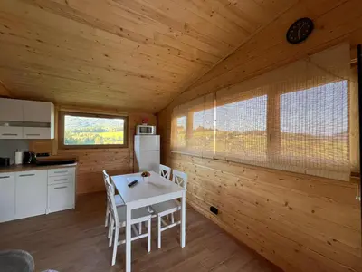 a kitchen with a table and chairs in a cabin at Domki- Limanowa domek 3 domek z jacuzzi i sauną in Limanowa