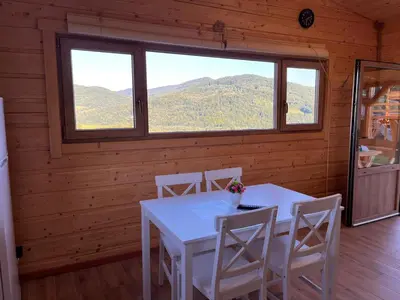 a dining room with a table and chairs and a window at Domki- Limanowa domek 3 domek z jacuzzi i sauną in Limanowa