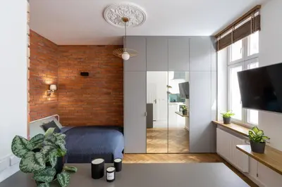 a bedroom with a bed and a brick wall at Apartment with balcony - Starowiślna 41 in Kraków