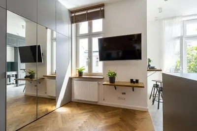 a living room with a tv and a large window at Apartment with balcony - Starowiślna 41 in Kraków