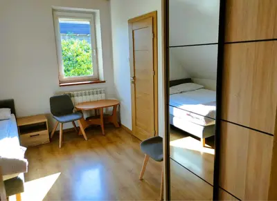 a small room with a bed and a table and a window at Pokoje gościnne Zawoja Centrum Henryk Hadka in Zawoja