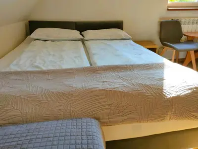 a large bed in a room with a chair at Pokoje gościnne Zawoja Centrum Henryk Hadka in Zawoja