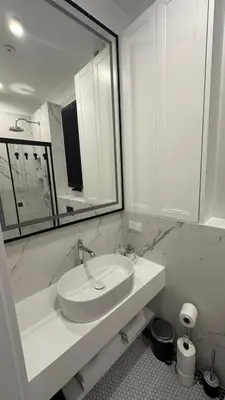 a white bathroom with a sink and a mirror at Cracow Apartments & Self check in & Free Parking in Kraków