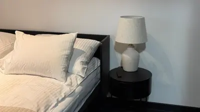 a bed with a lamp on a table next to it at Cracow Apartments & Self check in & Free Parking in Kraków