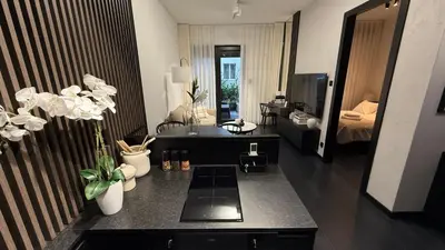 a bathroom with a sink and a living room at Cracow Apartments & Self check in & Free Parking in Kraków