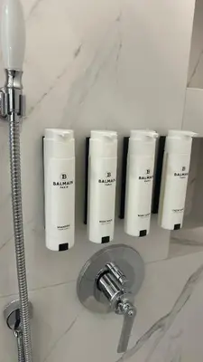 a bathroom counter with three bottles ofodorizers and a sink at Cracow Apartments & Self check in & Free Parking in Kraków