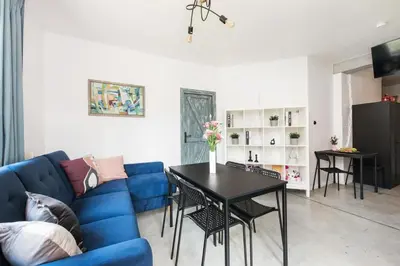 a living room with a blue couch and a table at Yellow villa in Zator