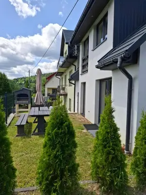 a picnic table in a yard next to a building at Ważka - apartament 6 osobowy in Krzeszów
