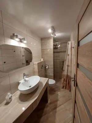 a bathroom with a white sink and a mirror at Ważka - apartament 6 osobowy in Krzeszów