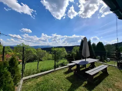 a picnic table and an umbrella in the grass at Ważka - apartament 6 osobowy in Krzeszów