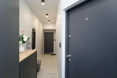 a corridor with a blue door in a hallway at K12 Apartments in Kraków