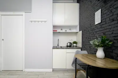 a kitchen with a table and a brick wall at K12 Apartments in Kraków