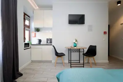 a bedroom with a table and two chairs and a kitchen at K12 Apartments in Kraków