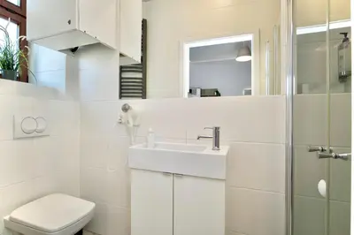 a white bathroom with a sink and a toilet at K12 Apartments in Kraków