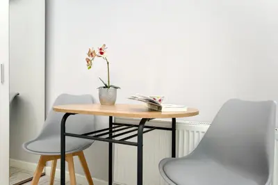 a table with two chairs and a vase with flowers on it at K12 Apartments in Kraków