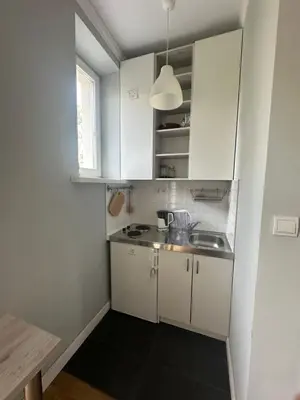 a small kitchen with white cabinets and a sink at Kujawska apartment in Kraków