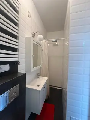 a white bathroom with a sink and a shower at Kujawska apartment in Kraków