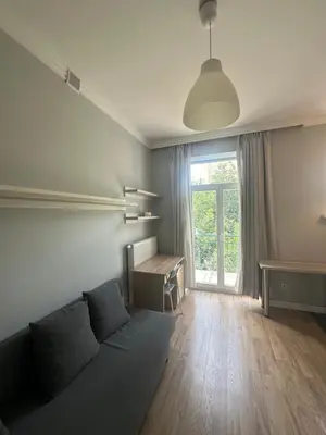 a living room with a couch and a desk and a window at Kujawska apartment in Kraków