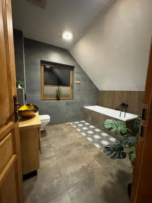 a bathroom with a tub and a toilet and a sink at Leśne Zacisze & Spa na wyłączność in Lubień