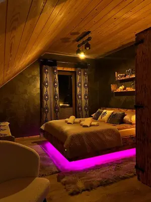 a bedroom with a bed with purple lighting at Leśne Zacisze & Spa na wyłączność in Lubień