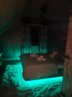 a bed with blue lights in a dark room at Leśne Zacisze & Spa na wyłączność in Lubień