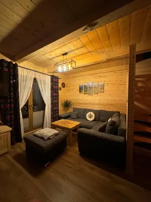 a living room with a couch and a table at Leśne Zacisze & Spa na wyłączność in Lubień