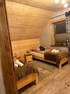 a room with two beds in a log cabin at Leśne Zacisze & Spa na wyłączność in Lubień