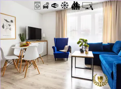 a living room with a blue couch and chairs at Aleja 69 Premium in Kraków