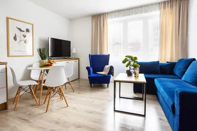 a living room with a blue couch and a table at Aleja 69 Premium in Kraków