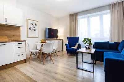a living room with a blue couch and a table at Aleja 69 Premium in Kraków