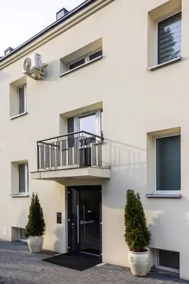 an apartment building with a balcony and a door at Aleja 69 Premium in Kraków