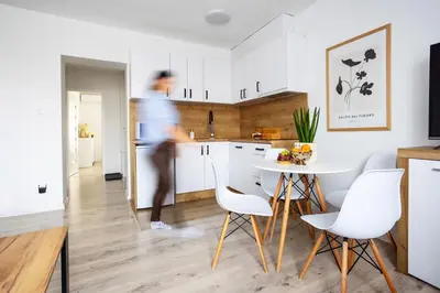 a man in a kitchen with a table and chairs at Aleja 69 Premium in Kraków