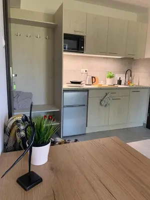 a table with two chairs and a television on the wall at Krakstop apartamenty in Kraków